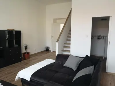 a living room with a couch and a staircase at Fine apartment in centrum of Slaný with Aircondition in Slaný