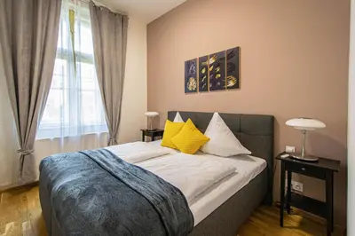 a bedroom with a bed with yellow pillows and a window at Stylish apartment in Prague best gastronomic area in Prague