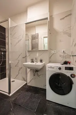 a bathroom with a washing machine and a sink at Stylish apartment in Prague best gastronomic area in Prague