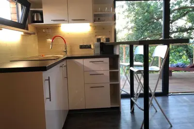 a kitchen with a sink and a counter with a chair at Chatka - C - Vyhlídka nad řekou in Zdiby