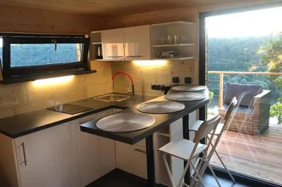 a kitchen with a counter with a sink and a balcony at Chatka - C - Vyhlídka nad řekou in Zdiby