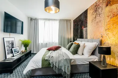 a bedroom with a bed and a large window at Romantic Apts Prague by Michal&Friends in Prague