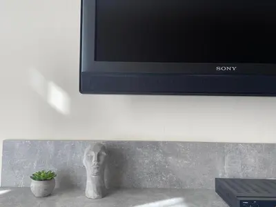 a statue of a head sitting under a television at Lokal apartment in Prague