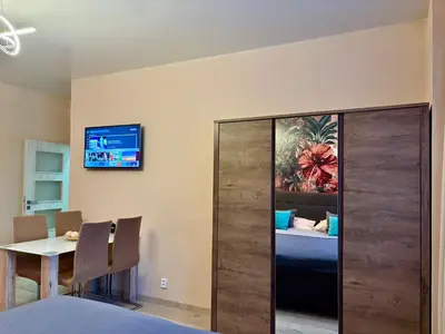 a bedroom with a bed and a table and a tv at Lokal apartment in Prague