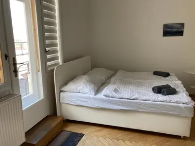 a small bed in a bedroom next to a window at Castle View Apartment in Prague