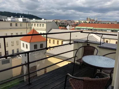 a balcony with a table and chairs and buildings at Castle View Apartment in Prague