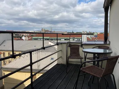 a balcony with two chairs and a table with a view at Castle View Apartment in Prague