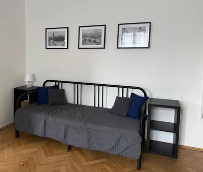 a bed in a room with three pictures on the wall at Castle View Apartment in Prague