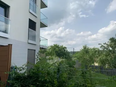 a building with a view of a field and trees at byt Panorama Hlubočepy in Prague