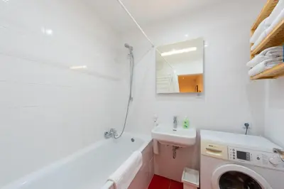 a white bathroom with a sink and a washing machine at BRIGHT CHARMING Apt with TERRACE, PARKING & AirCo. in Prague