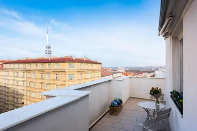 a balcony with a table and a view of a building at BRIGHT CHARMING Apt with TERRACE, PARKING & AirCo. in Prague