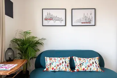a blue couch with two pillows in a living room at BRIGHT CHARMING Apt with TERRACE, PARKING & AirCo. in Prague