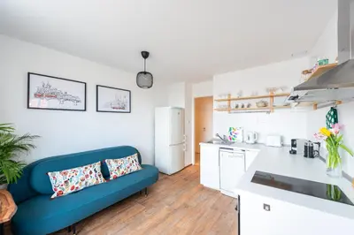 a living room with a blue couch in a kitchen at BRIGHT CHARMING Apt with TERRACE, PARKING & AirCo. in Prague