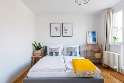 a bedroom with a bed with a yellow blanket on it at BRIGHT CHARMING Apt with TERRACE, PARKING & AirCo. in Prague
