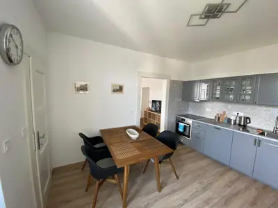 a kitchen with a table and chairs in a room at Apartman Xaveriova in Prague