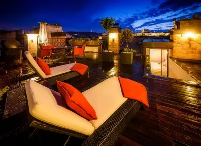 a balcony with couches and tables on a roof at Triplex Kings Apartment in Old Town in Prague
