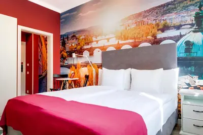 a bedroom with a large bed with a red wall at Revelton Studios Prague in Prague