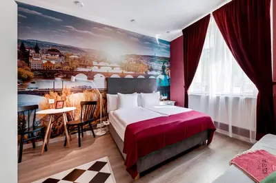 a hotel room with a large bed and a painting on the wall at Revelton Studios Prague in Prague