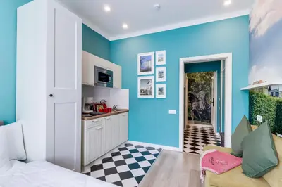 a kitchen with blue walls and a checkered floor at Revelton Studios Prague in Prague