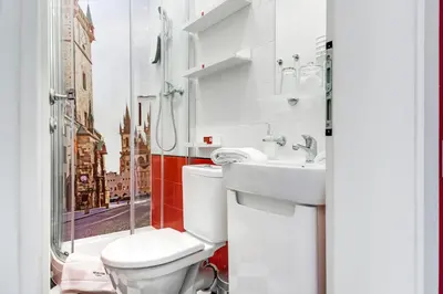 a bathroom with a toilet and a sink and a window at Revelton Studios Prague in Prague