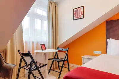 a bedroom with a bed and two chairs and a table at Revelton Studios Prague in Prague
