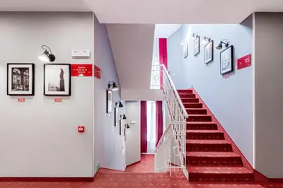 a staircase in a building with red floors and white walls at Revelton Studios Prague in Prague