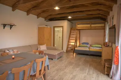 a living room with a table and a couch and a bed at Útulný domek v zahradě v Unhošti nedaleko letiště in Unhošť