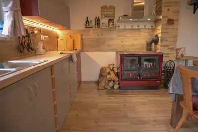 a kitchen with wooden floors and a counter and a stove at Útulný domek v zahradě v Unhošti nedaleko letiště in Unhošť