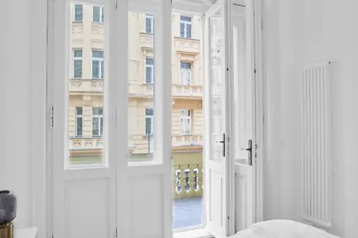 a small table and a blue chair on a balcony at Pytloun Bristol Residence Prague in Prague