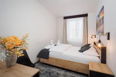 a bedroom with a bed and a table and a window at Prague Old Town Liliova Garden in Prague