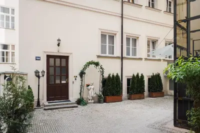 a white building with an arch and a door at Prague Old Town Liliova Garden in Prague