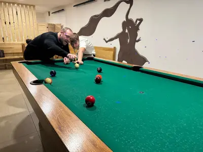 a man and a child playing a game of pool at Hotel & wellness Hejtmanka in Mladá Boleslav