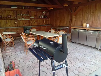a grill in a kitchen with a table and chairs at Bohemica Apartman 4 in Kouřim