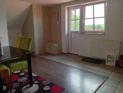 a living room with a table and chairs and a window at Bohemica Apartman 4 in Kouřim