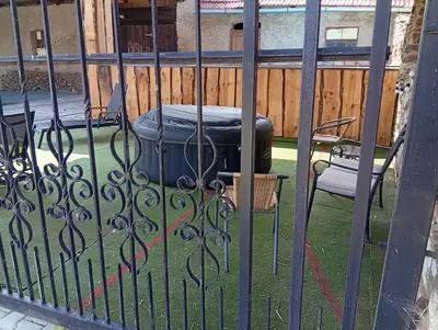 a gate with a trash can and a chair at Bohemica Apartman 4 in Kouřim
