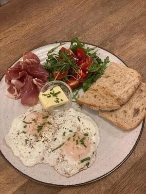 a plate of eggs and bread with meat and vegetables at Time Cafe & Penzion in Příbram