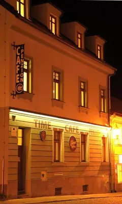 a building with a sign on the side of it at Time Cafe & Penzion in Příbram