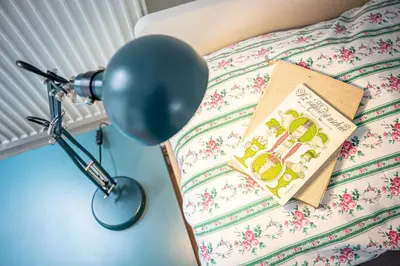 a book sitting on a bed next to a lamp at Vila Lumír in Poděbrady
