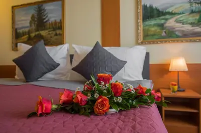 a bouquet of flowers on a bed in a bedroom at TOP HOTEL Praha in Prague