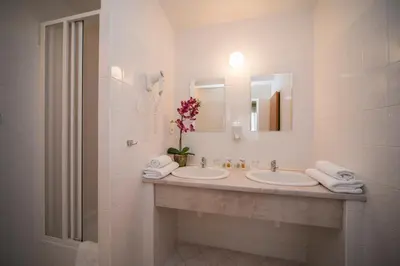 a white bathroom with two sinks and a mirror at TOP HOTEL Praha in Prague