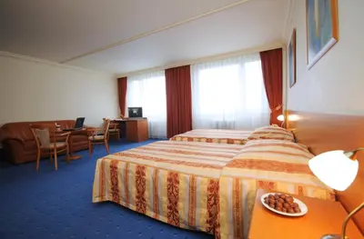 a hotel room with two beds and a table at TOP HOTEL Praha in Prague