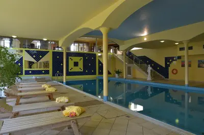 a swimming pool with benches next to a swimming pool at TOP HOTEL Praha in Prague