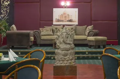 a living room with a couch and a statue at TOP HOTEL Praha in Prague