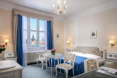 a bedroom with a bed and a table and chairs at Ambassador Zlata Husa in Prague