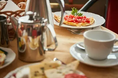 a table with plates of food and a cup of coffee at Ambassador Zlata Husa in Prague
