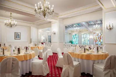 a banquet hall with tables and chairs and a chandelier at Ambassador Zlata Husa in Prague