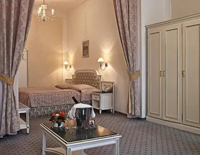 a hotel room with two beds and a table at Ambassador Zlata Husa in Prague