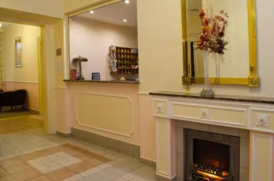 a living room with a fireplace and a mirror at Anna Hotel in Prague