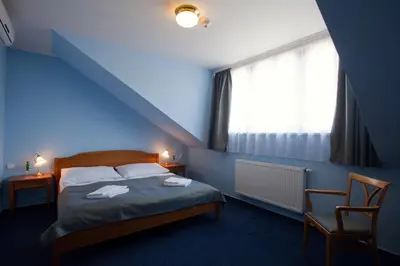 a blue bedroom with a bed and a window at Anna Hotel in Prague