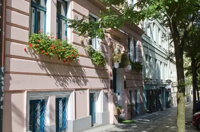 a pink building with windows and flower boxes on it at Anna Hotel in Prague